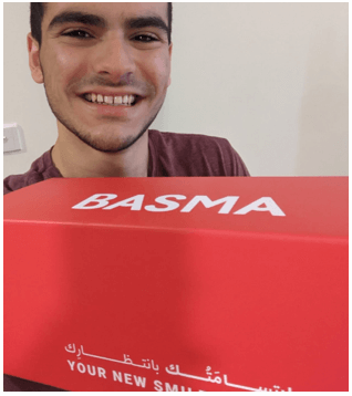 Young man is holding up the BASMA Aligner Kit.