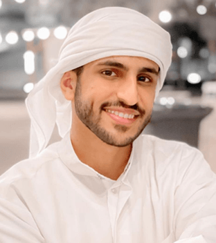 شاب سعودي يرتدي اللباس التقليدي الأبيض ويظهر مبتسماً
